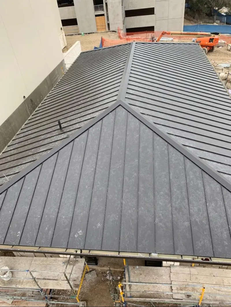 Commercial metal roof construction with crane equipment in Clark